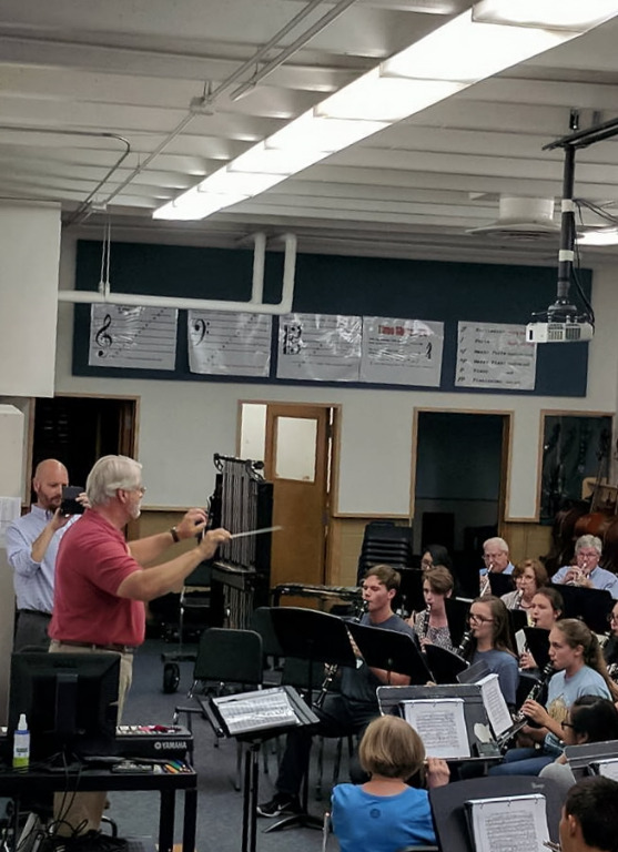 Charles Craig leading the students and alumni during rehearsal